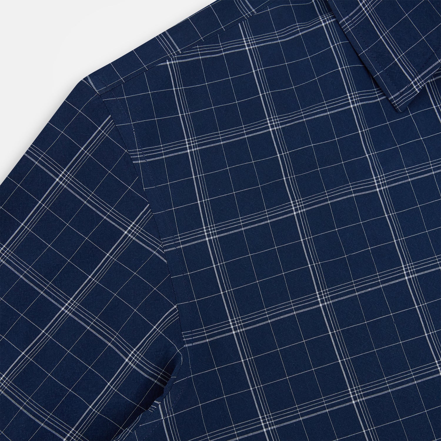 View 6 of product The Indigo and White Thin Plaid Check Windsor Shirt by Turnbull & Asser, a long-sleeve button-up with white buttons, is shown laid flat on a white background.