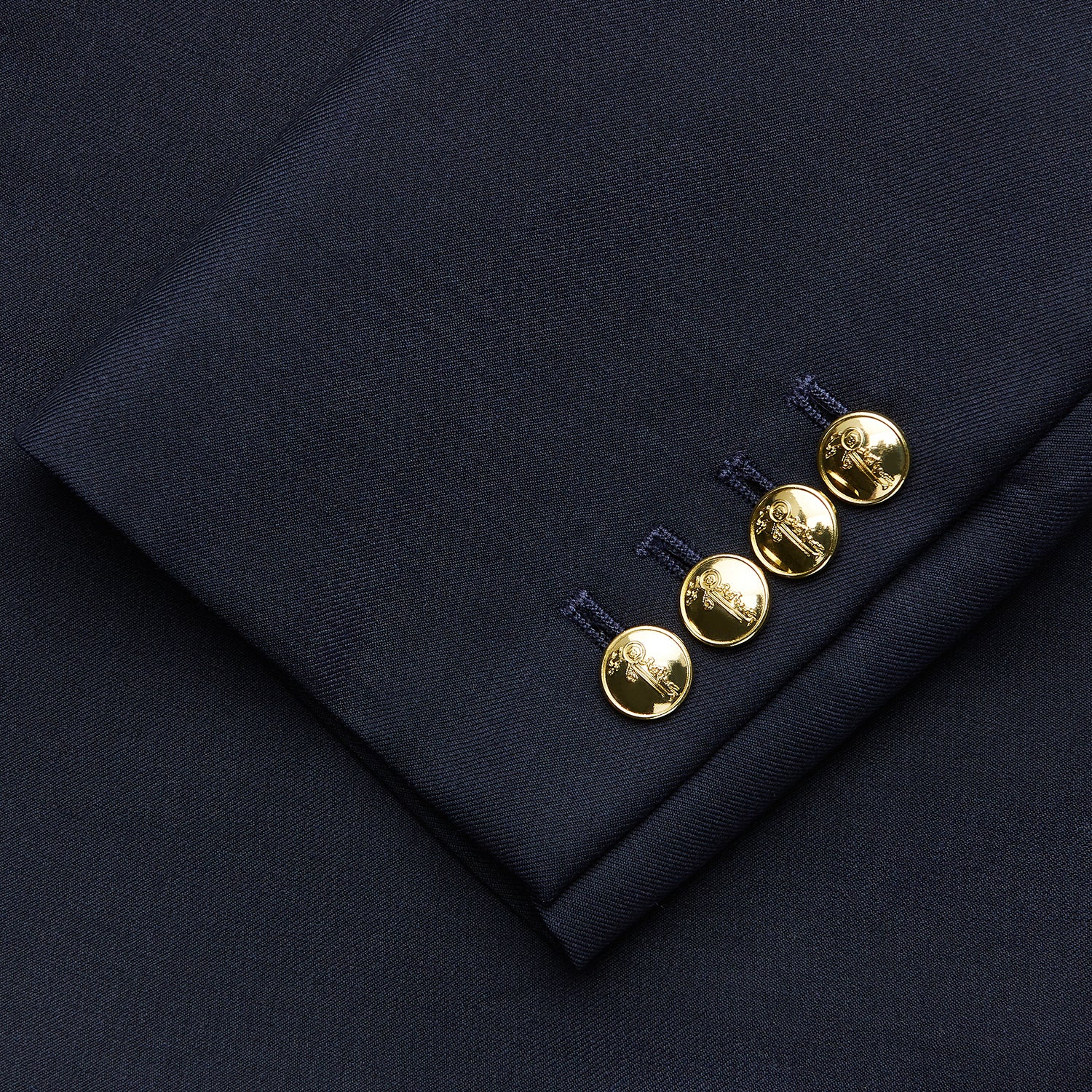 View 4 of product The Turnbull & Asser Navy Plain Wool Single Breasted Blazer, with brass front and cuff buttons and an asymmetric pocket design, is shown laid flat on a white background.