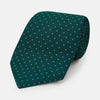 View 1 of product The Turnbull & Asser Blue and Forest Green Micro Dot Silk Tie features small light blue polka dots, rolled up against a white background—an elegant men’s accessory for any occasion.