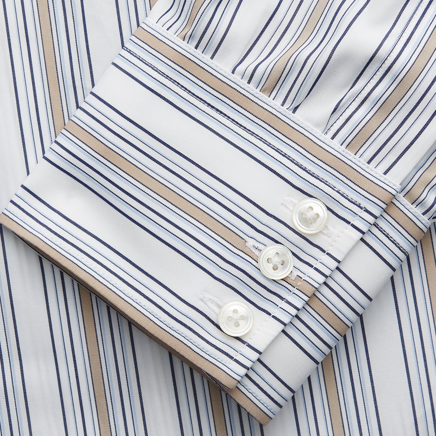 View 3 of product The Turnbull & Asser Sand Multi Stripe Regular Fit Shirt features a T&A collar, 3 button cuffs, and vertical blue, white, and light brown stripes. The shirt is shown neatly laid flat on a white background.