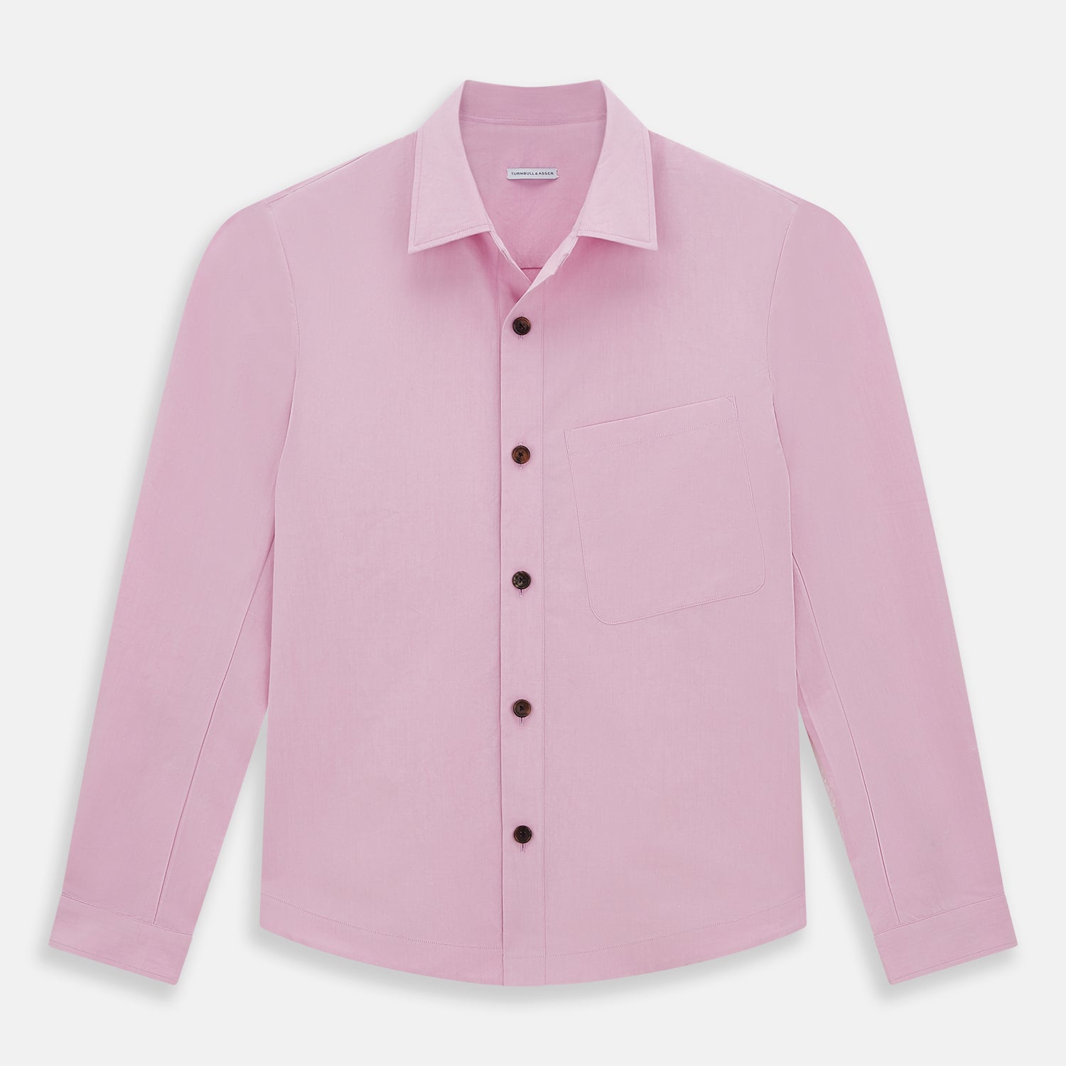 View 1 of product The Pink Hyde Overshirt by Turnbull & Asser is a long-sleeved, light pink sanforised cotton shirt with a left chest pocket and dark buttons—an elegant, laid-back alternative to a blazer.