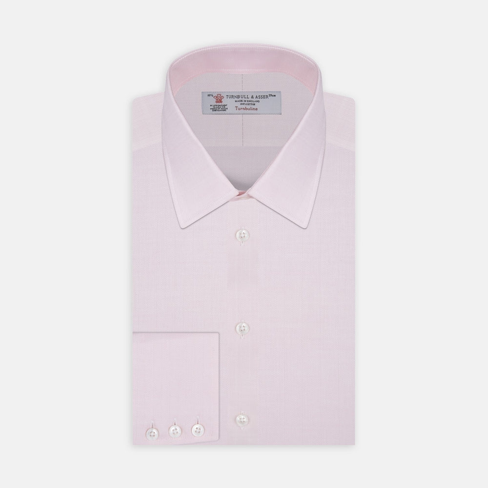 Close-up of Turnbull & Asser's Pink Herringbone Cotton Fabric, featuring a subtle herringbone pattern, displayed in a circular frame on a light gray background.