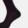 View 4 of product A single Navy/Red Motif Mid-Length Sock by Turnbull & Asser, displayed upright on a white background. The sock features a calf-length style, ribbed cuff, hand-linked toe for comfort, and a subtle red pattern.