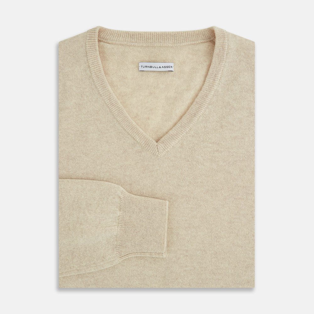The Turnbull & Asser Ivory Cashmere V-Neck Jumper, with long sleeves and ribbed cuffs and hem, is shown against a plain white background.