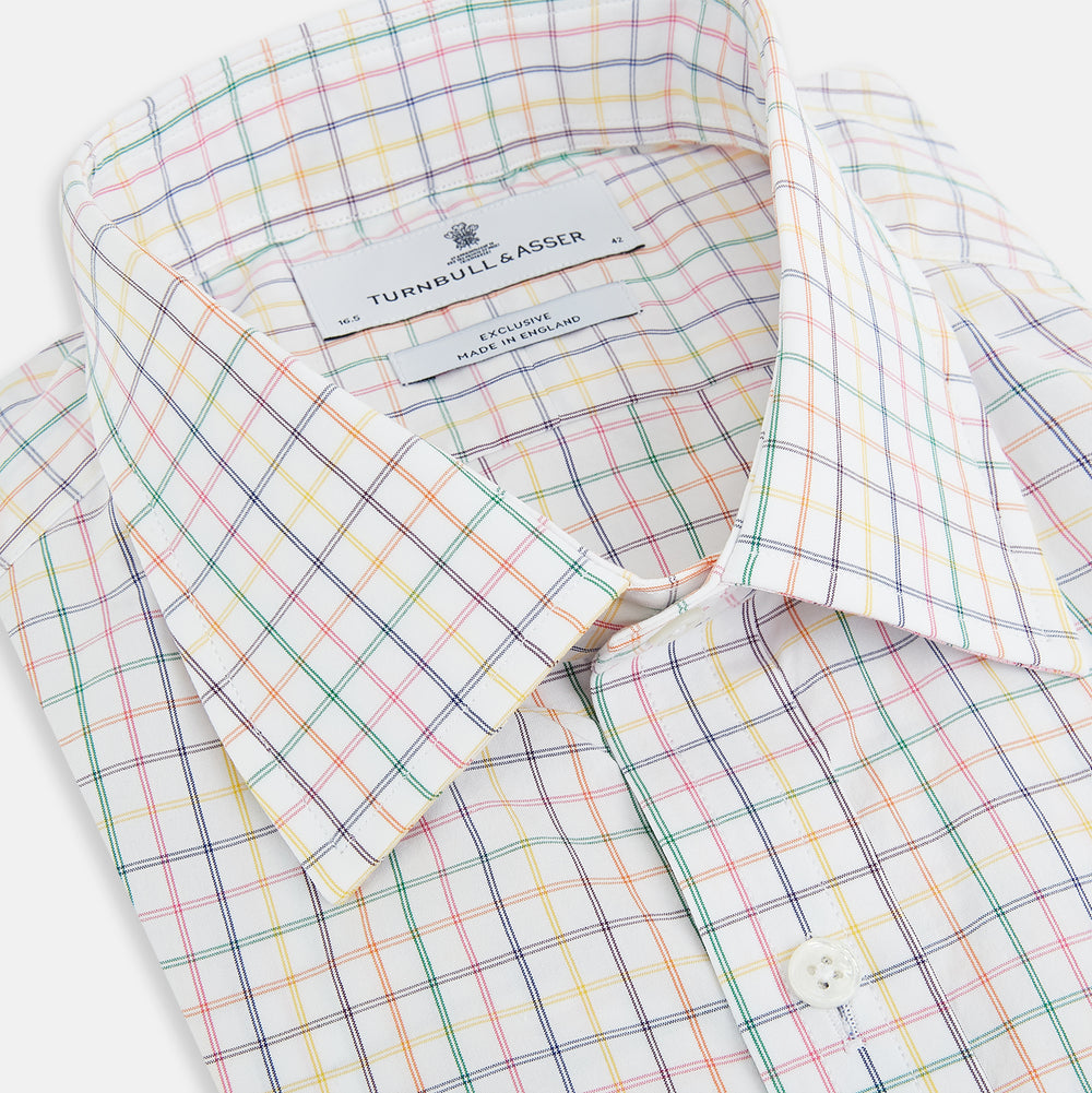 The Rainbow Double Grid Check Mayfair Shirt by Turnbull & Asser features a white base with thin blue, red, and green checks and a T&A collar. It’s displayed neatly laid flat on a white background.