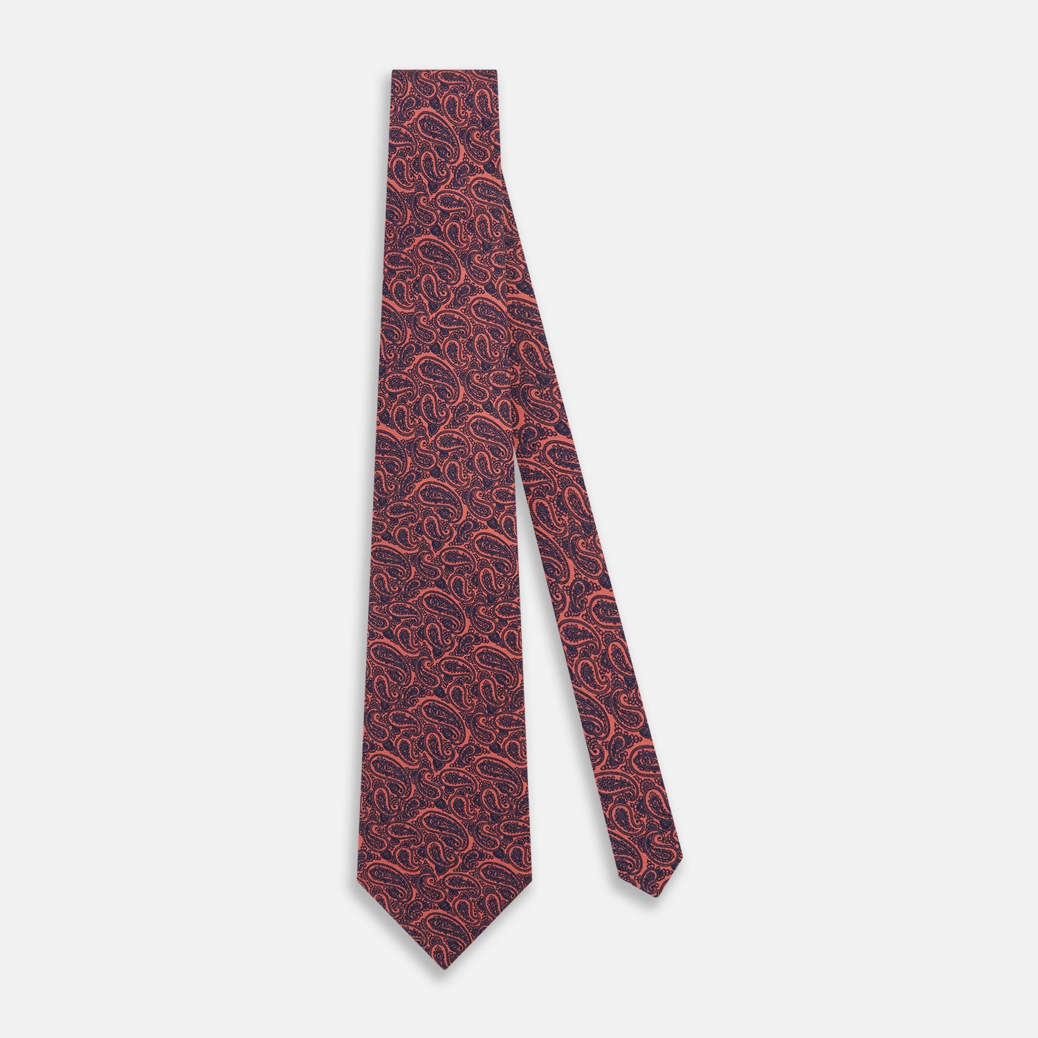 View 2 of product The Turnbull & Asser Orange Paisley Silk Tie, crafted from fine English silk, features an elegant paisley pattern and is stylishly rolled up on a plain white background.