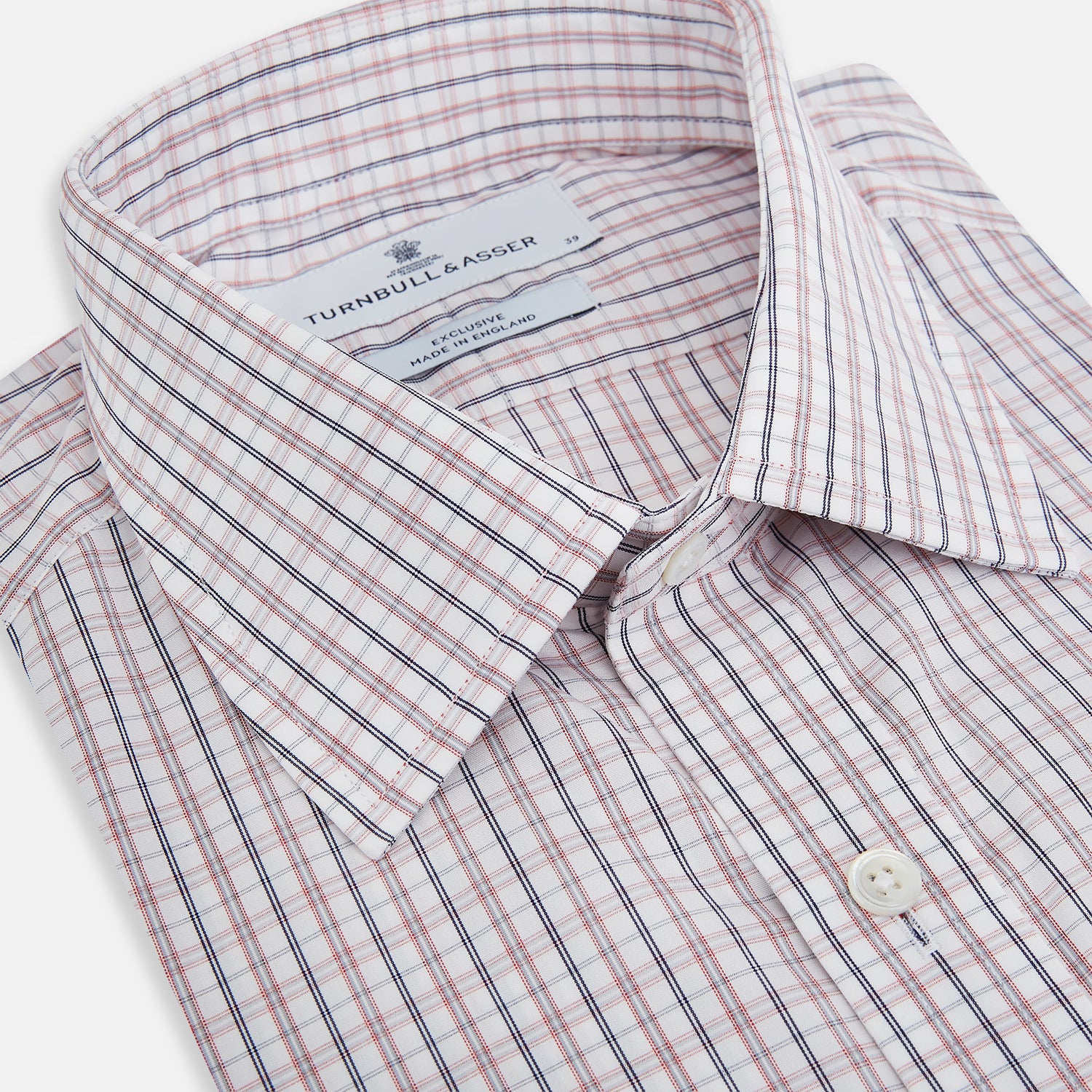 View 2 of product The Turnbull & Asser Red and Blue Multi Check Mayfair Shirt is a long-sleeve button-down made from Italian cotton with a white base and a light red and blue check pattern, shown laid flat on a white background.