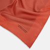 View 2 of product The Orange Stripe Silk Pocket Square by Turnbull & Asser features thin black vertical lines and "TURNBULL & ASSER HAND PRINTED IN ENGLAND" in the corner, neatly folded on a white background.