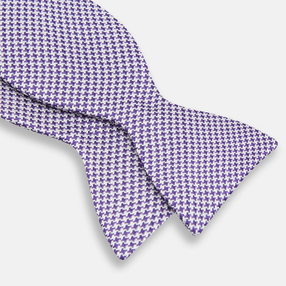 The Turnbull & Asser Purple and White Houndstooth Silk Bow Tie, ideal for formalwear, is shown against a white background.