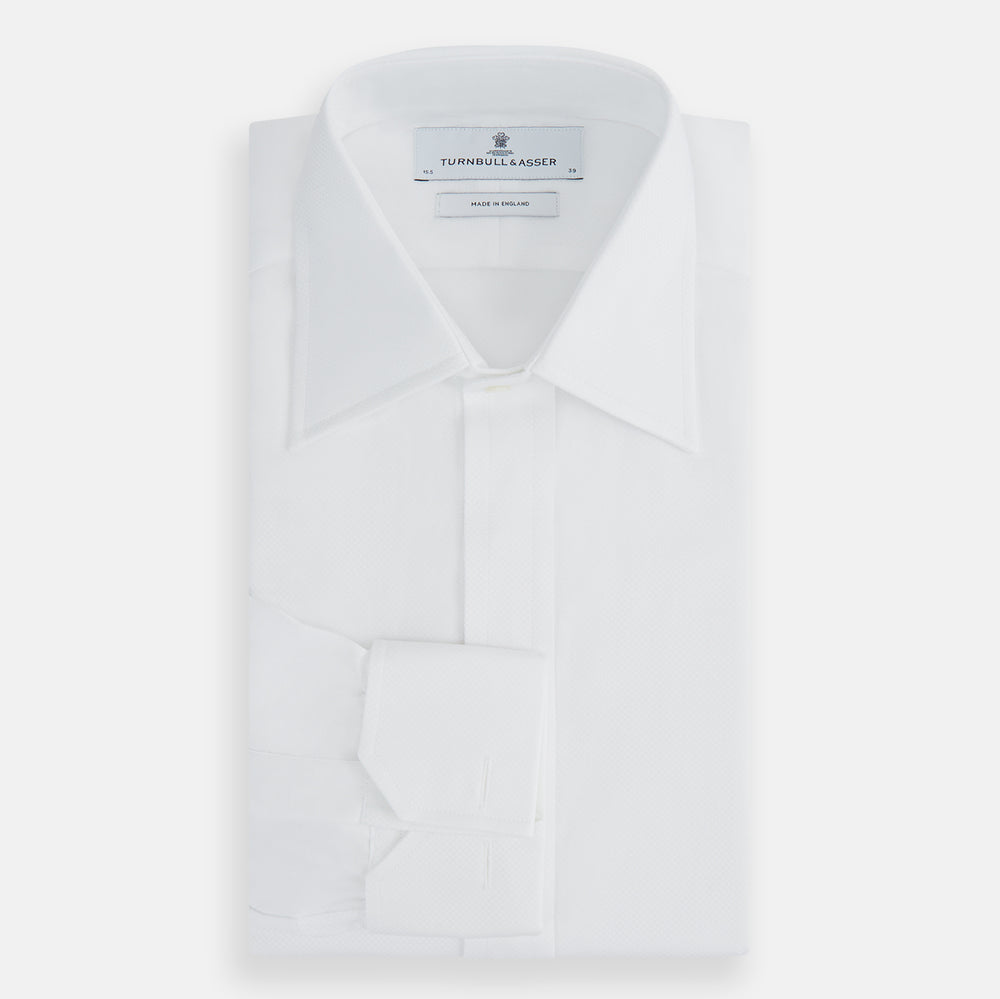 The Turnbull & Asser Casino Royale White Dress Shirt, as seen on James Bond, features a classic Bond collar, button-down front, and buttoned cuffs, shown on a white background.