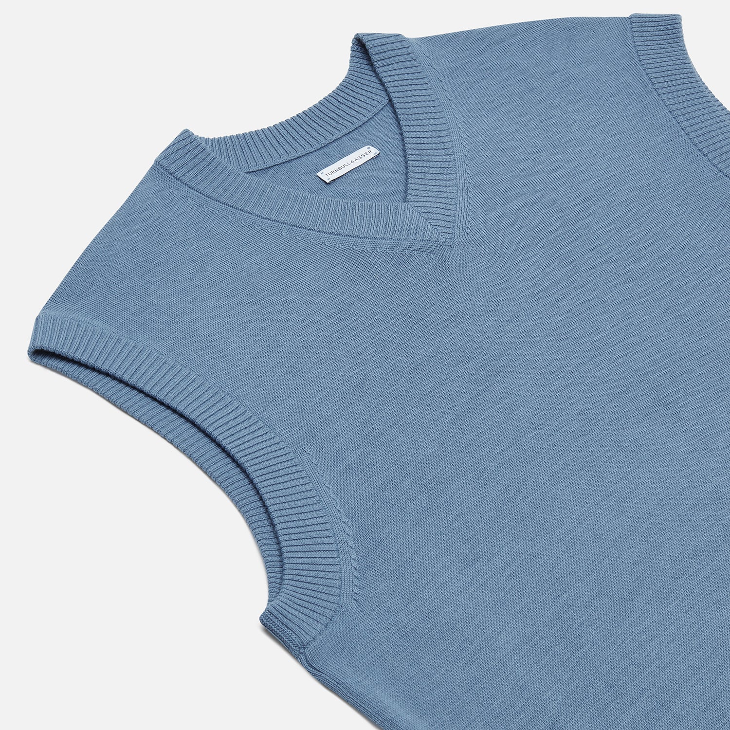 View 2 of product The Turnbull & Asser Pale Blue Fine Merino V-Neck Vest features a sleeveless design, knit texture, and classic V-neckline, shown against a plain white background.
