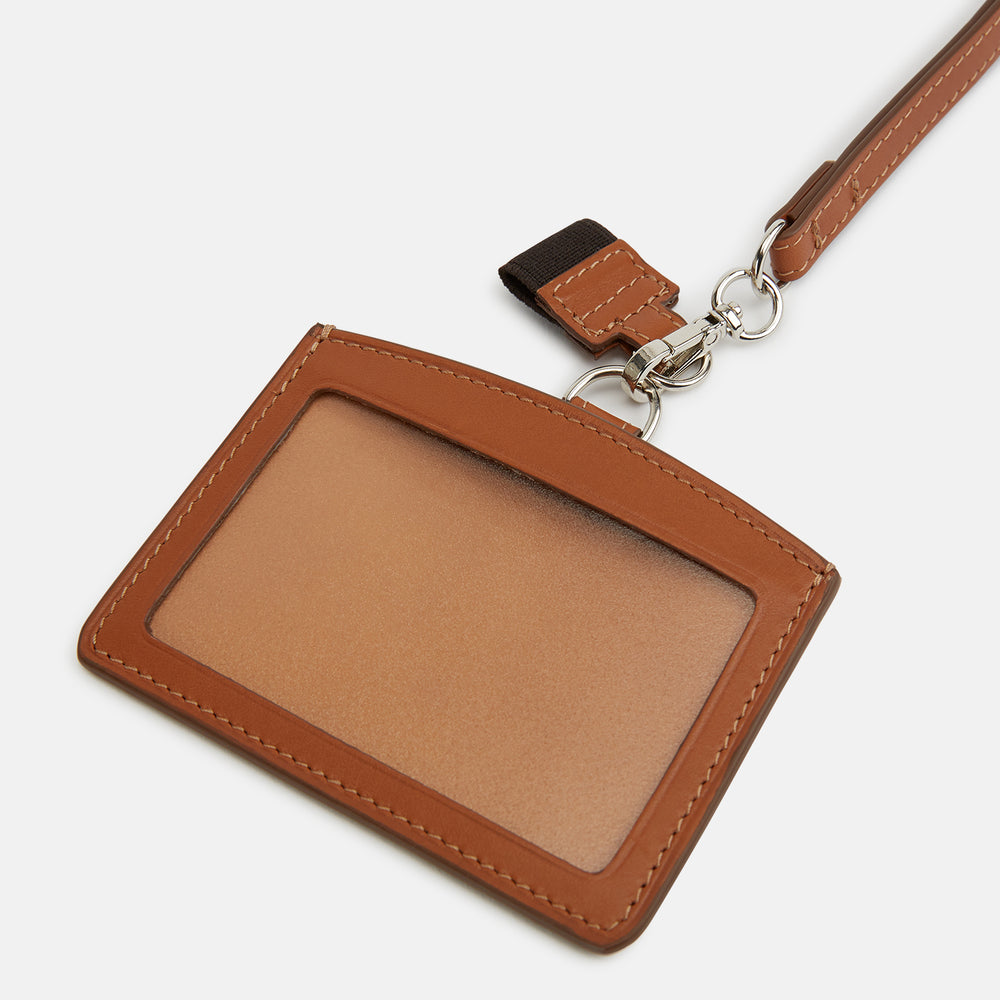 The Turnbull & Asser Camel ID Card Holder, shown on a white background, features Italian leather in brown with a matching lanyard, silver clasp, keychain tag, and "Turnbull & Asser" embossed in gold lettering.