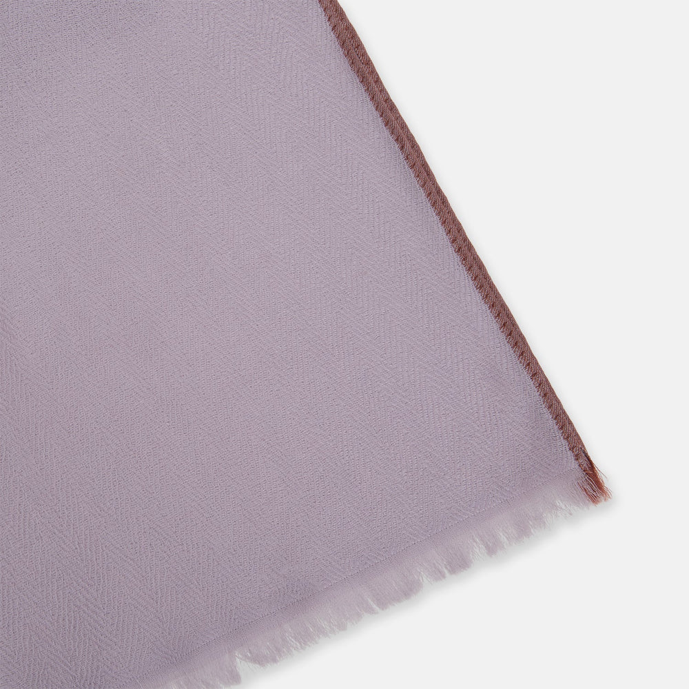 The Lilac Cashmere Scarf by Turnbull & Asser features a soft texture and unfinished, slightly frayed edges—an elegant accessory for any formal wardrobe.
