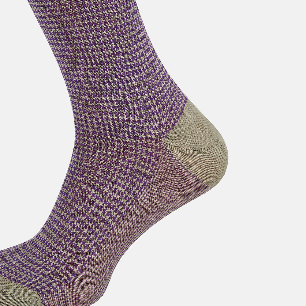 The Turnbull & Asser Concrete Houndstooth Mid-Length Sock features a purple and black houndstooth pattern with beige cuff, heel, and toe, crafted from soft cotton and shown on a plain white background.