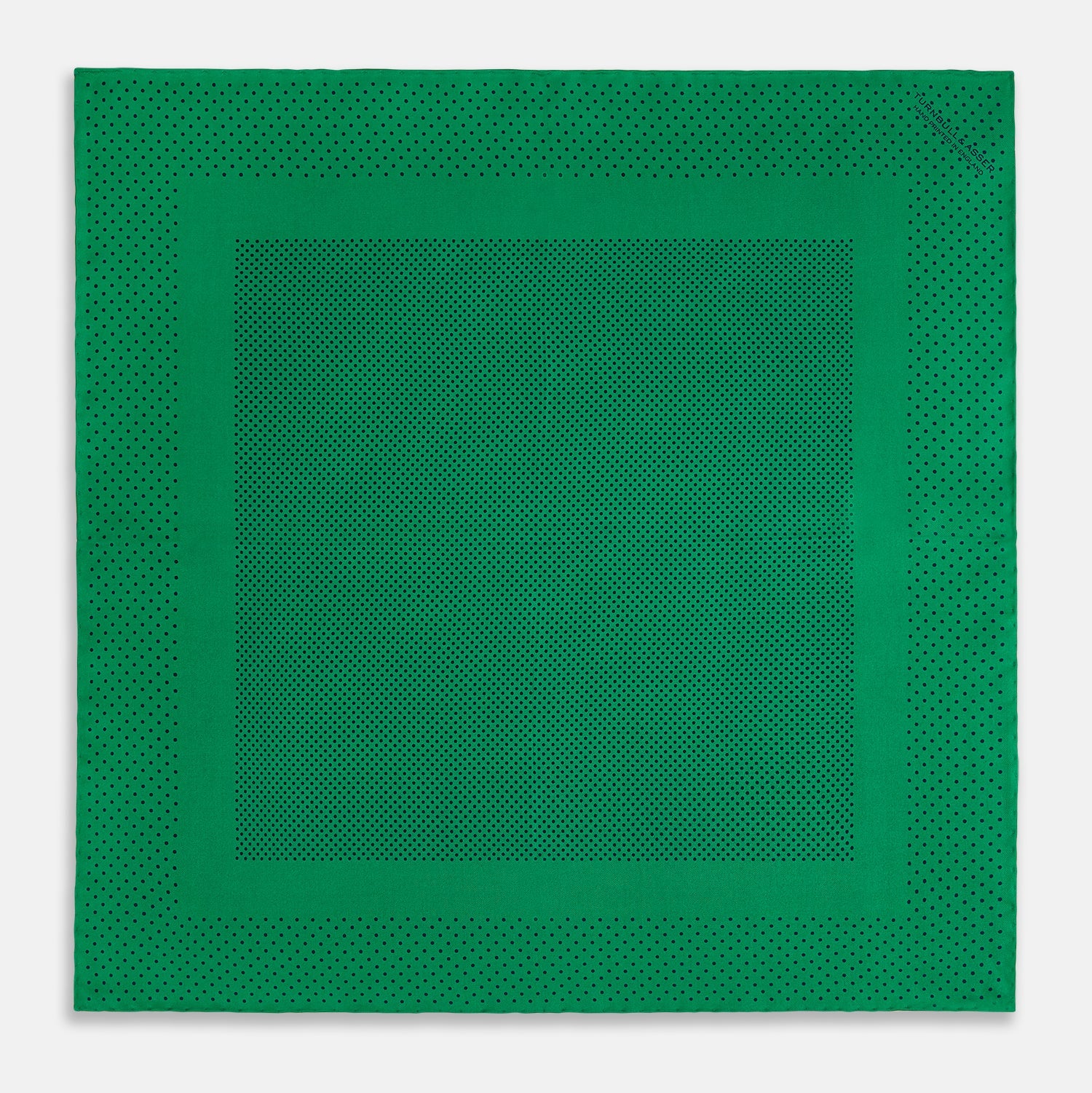 View 4 of product The Turnbull & Asser Green Dot Silk Pocket Square is handmade in England and shown neatly folded, revealing the front and part of the underside against a white background.