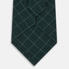 View 3 of product The Turnbull & Asser Light Petrol Dotted Check Pattern Printed Silk Tie is neatly rolled and displayed on a plain white background.