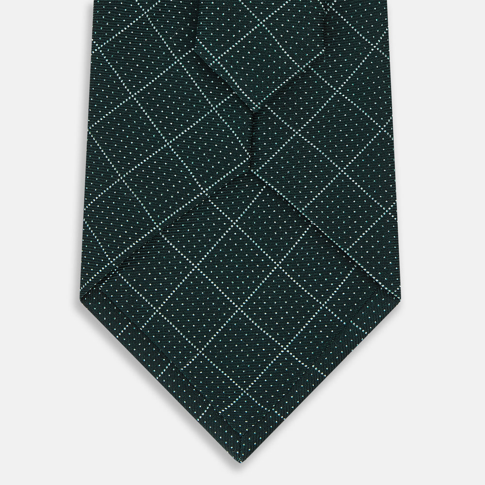 The Turnbull & Asser Light Petrol Dotted Check Pattern Printed Silk Tie is neatly rolled and displayed on a plain white background.