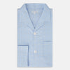 View 5 of product The Turnbull & Asser Blue Prince of Wales Check Pyjama Shirt features long sleeves, a notched collar, a left chest pocket, and a subtle check pattern, shown laid flat on a white background.