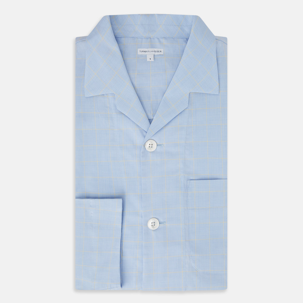 The Turnbull & Asser Blue Prince of Wales Check Pyjama Shirt features long sleeves, a notched collar, a left chest pocket, and a subtle check pattern, shown laid flat on a white background.