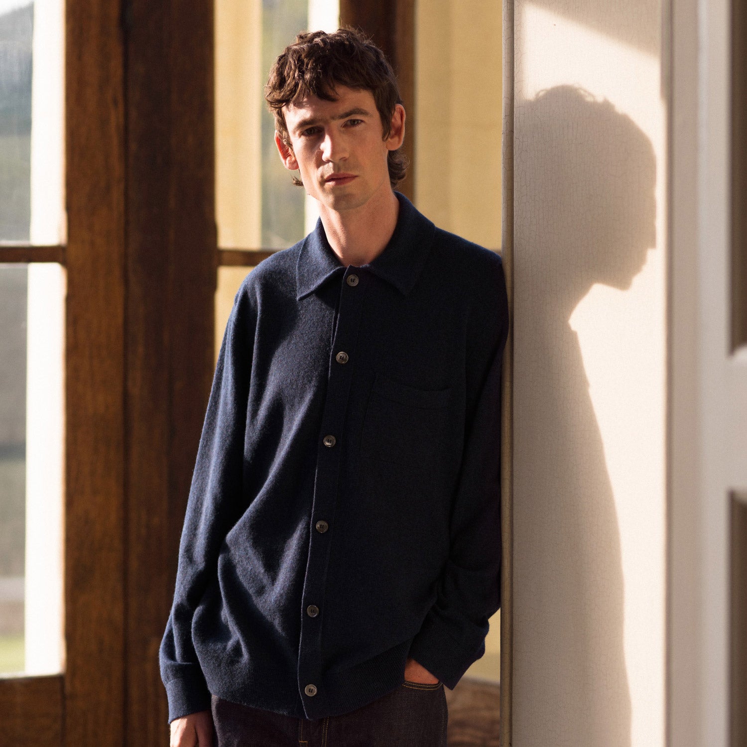 View 5 of product The Turnbull & Asser Navy Cashmere Duncan Knitted Shirt, a button-up with collar, long sleeves, chest pocket, and straight hem, is shown laid flat on a white background.