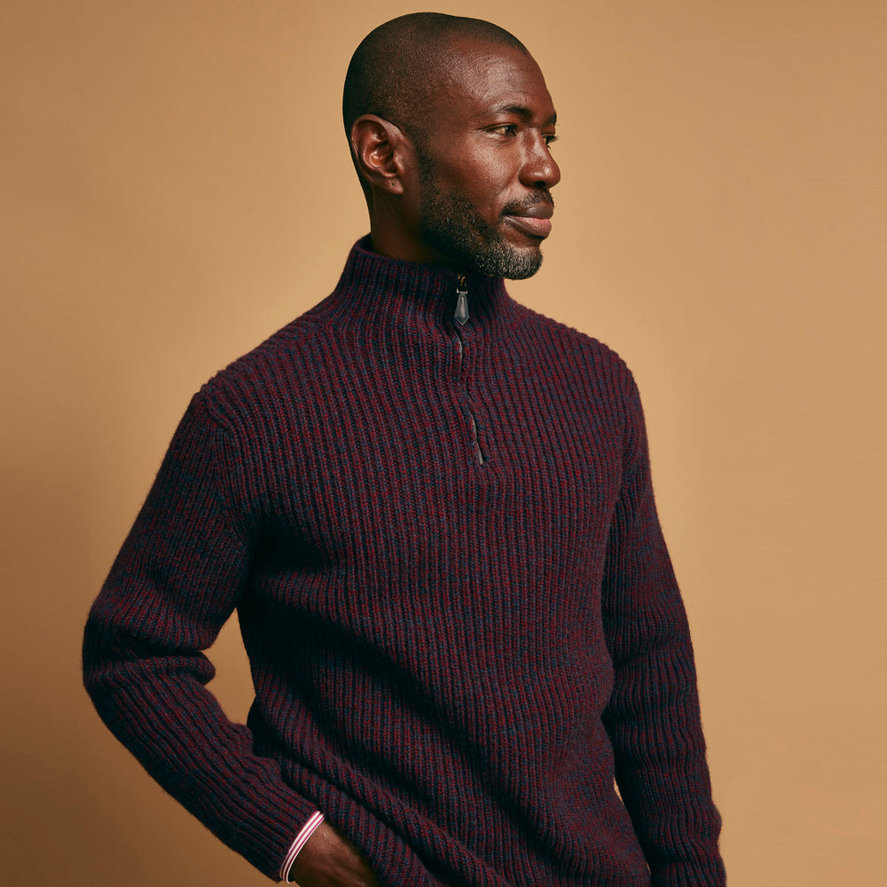 The Turnbull & Asser Burgundy Mullion Half Zip Rib Cashmere Jumper features a high collar and half-zip front in dark red and navy cashmere, shown laid flat on a white background—ideal for an elevated casual look.