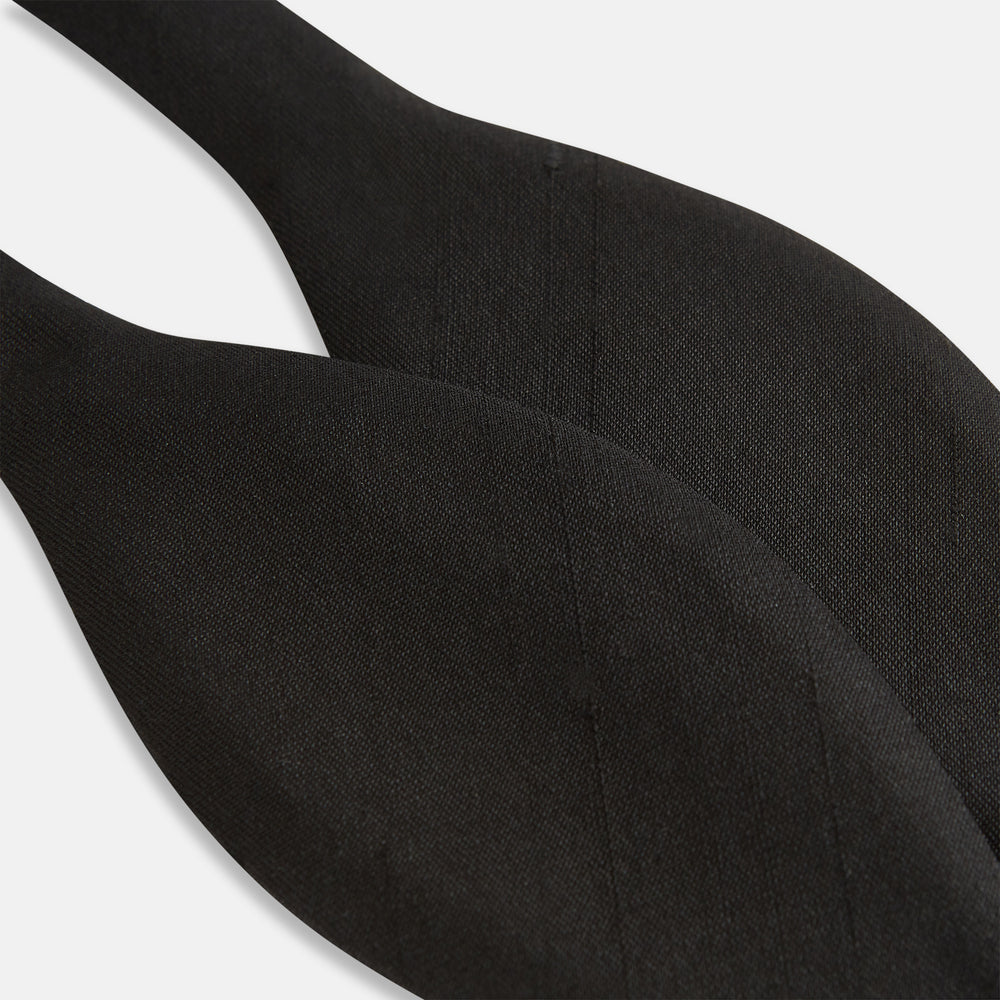 The Casino Royale Bow Tie by Turnbull & Asser, as seen on James Bond, is a classic black Shantung silk bow tie with a smooth, slightly shiny finish, shown against a plain white background.