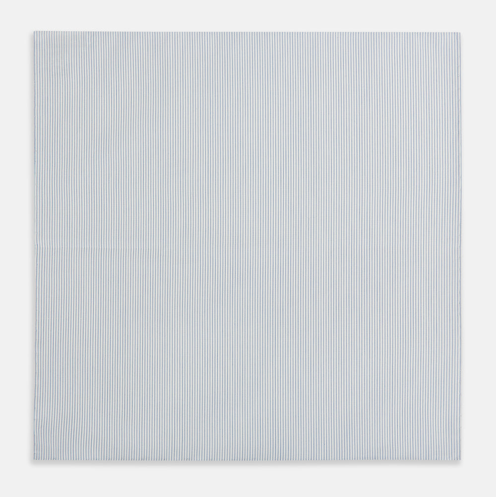 The Turnbull & Asser Sky Blue Hairline Stripe Hand-Rolled Handkerchief, featuring thin blue and white stripes and hand-rolled edges, is displayed flat on a white background.