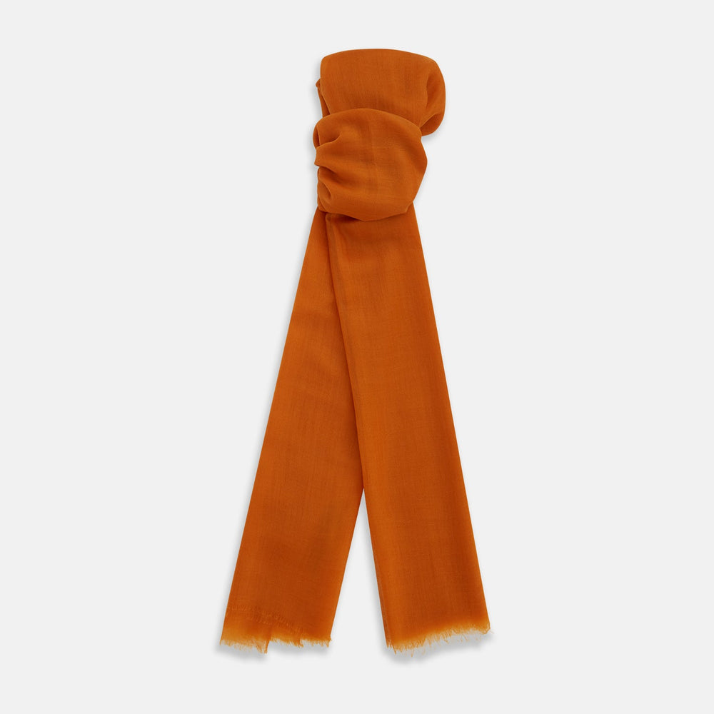 The Orange Cashmere Scarf by Turnbull & Asser features a soft texture, fringed edges, and a rich orange hue—an elegant luxury accessory displayed on a white background.