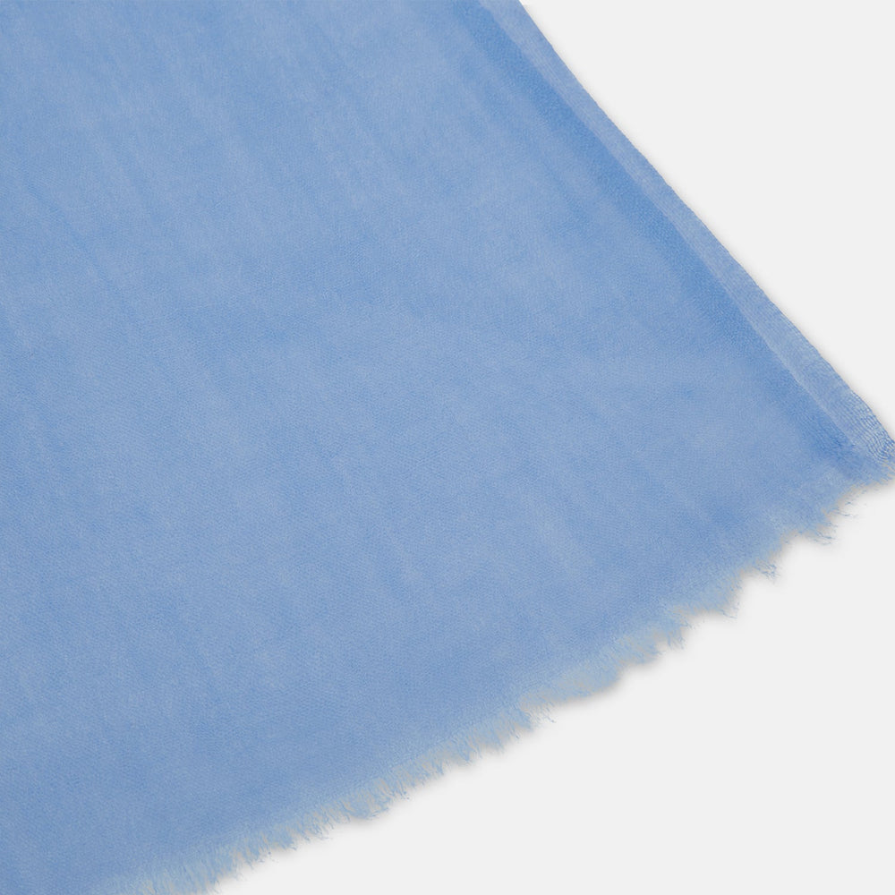 The Azzurro Cashmere Scarf by Turnbull & Asser is shown in light blue, hand-dyed cashmere, semi-sheer and loosely knotted, displayed against a plain white background.