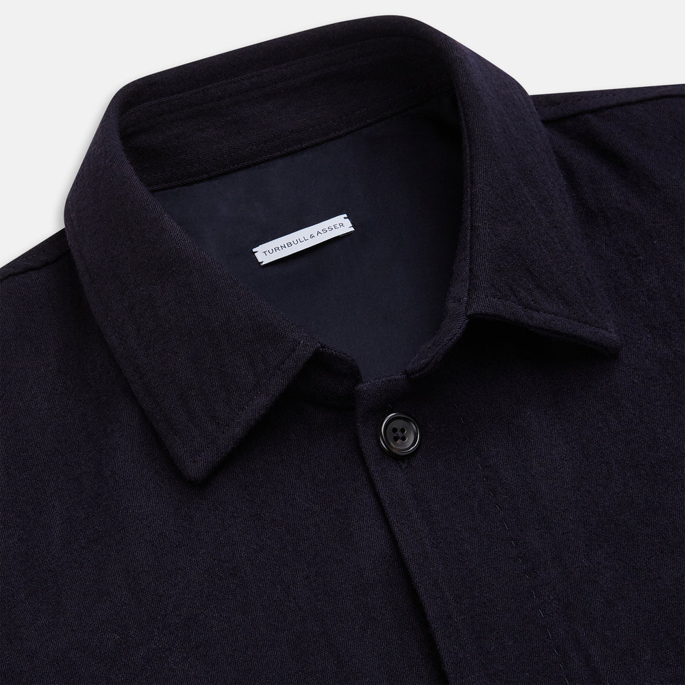 A navy button-up Primrose overshirt by Turnbull & Asser with a classic collar, two side pockets, a left chest pocket, and buttoned cuffs—an ideal blazer alternative, shown on a plain white background.