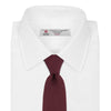 View 2 of product The Turnbull & Asser 7 fold Grenadine Silk Plain Tie is shown rolled on a white background, highlighting its textured maroon design as a versatile addition to any wardrobe.