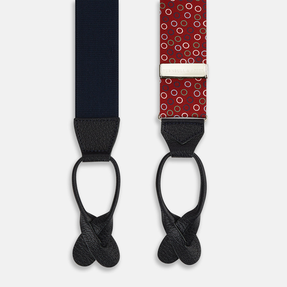 Pink and navy circle red adjustable silk and navy leather braces by Turnbull & Asser, arranged in an M shape on a white background—a refined choice for sartorial styling and standout men’s accessories.