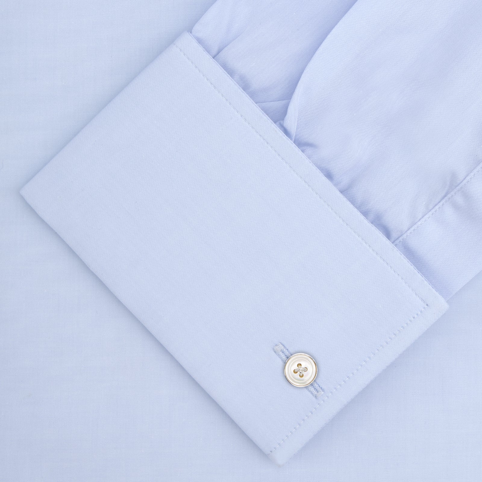 View 4 of product A neatly folded Turnbull & Asser Two-Fold 120 Light Blue Shirt, featuring a regent collar and double cuffs, is displayed against a plain white background.