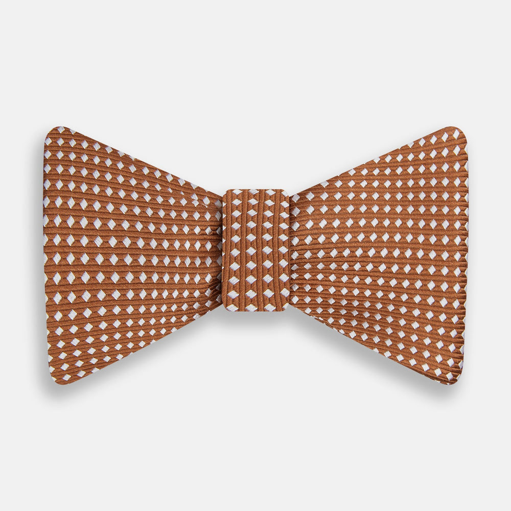 The Turnbull & Asser Brown and White Diamond Silk Bow Tie features a diamond pattern, ideal for formal occasions, showcased on a white background.