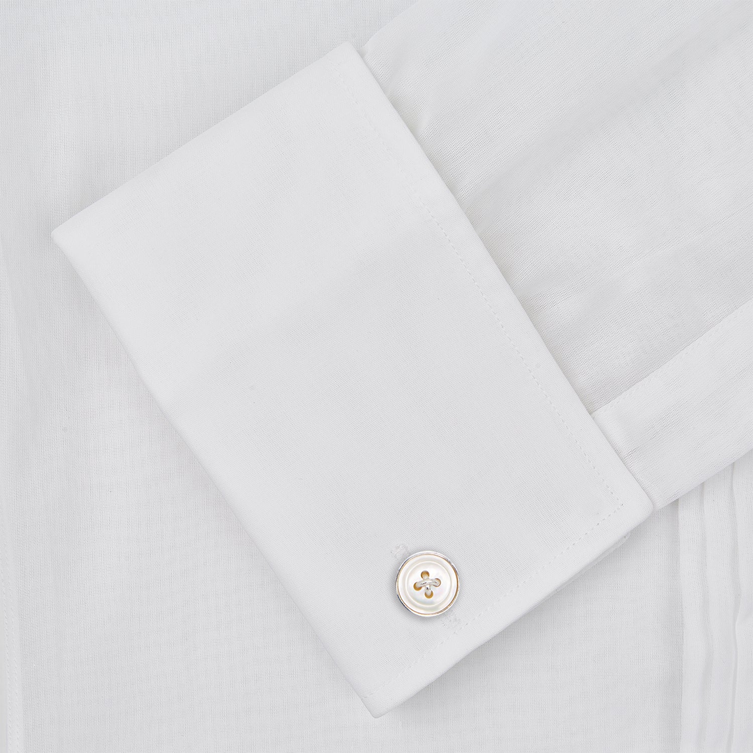 View 10 of product The Die Another Day Inspired Voile Dress Shirt by Turnbull & Asser features a white pleated front, button-down closure, and classic collar—laid flat on white to showcase its timeless James Bond style.