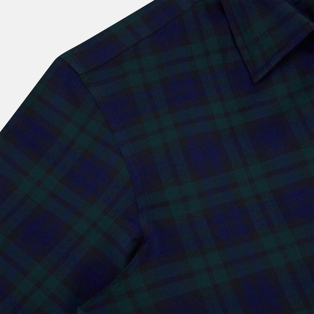 The Turnbull & Asser Black Watch Tartan Windsor Shirt is a long-sleeve, button-up shirt with a dark green and navy tartan pattern, white buttons, collar, and curved hem—showcasing British craftsmanship on a plain white background.