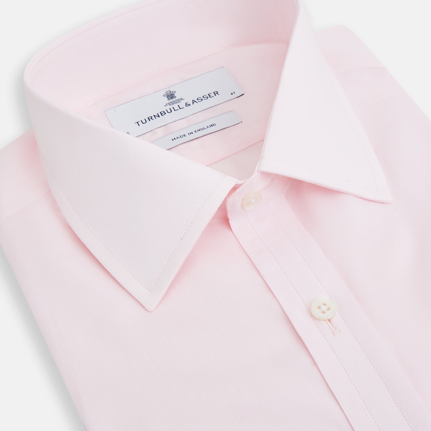 View 2 of product The Turnbull & Asser Pink Mayfair Shirt features long sleeves, a classic collar, and white buttons—a refined choice for any men's wardrobe. Laid flat against a white background, it highlights timeless style and craftsmanship.