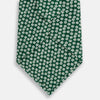 View 3 of product The Turnbull & Asser Forest Green Flower Patterned Silk Tie, crafted from fine English silk, features a repeating white floral design and is shown rolled up on a white background.