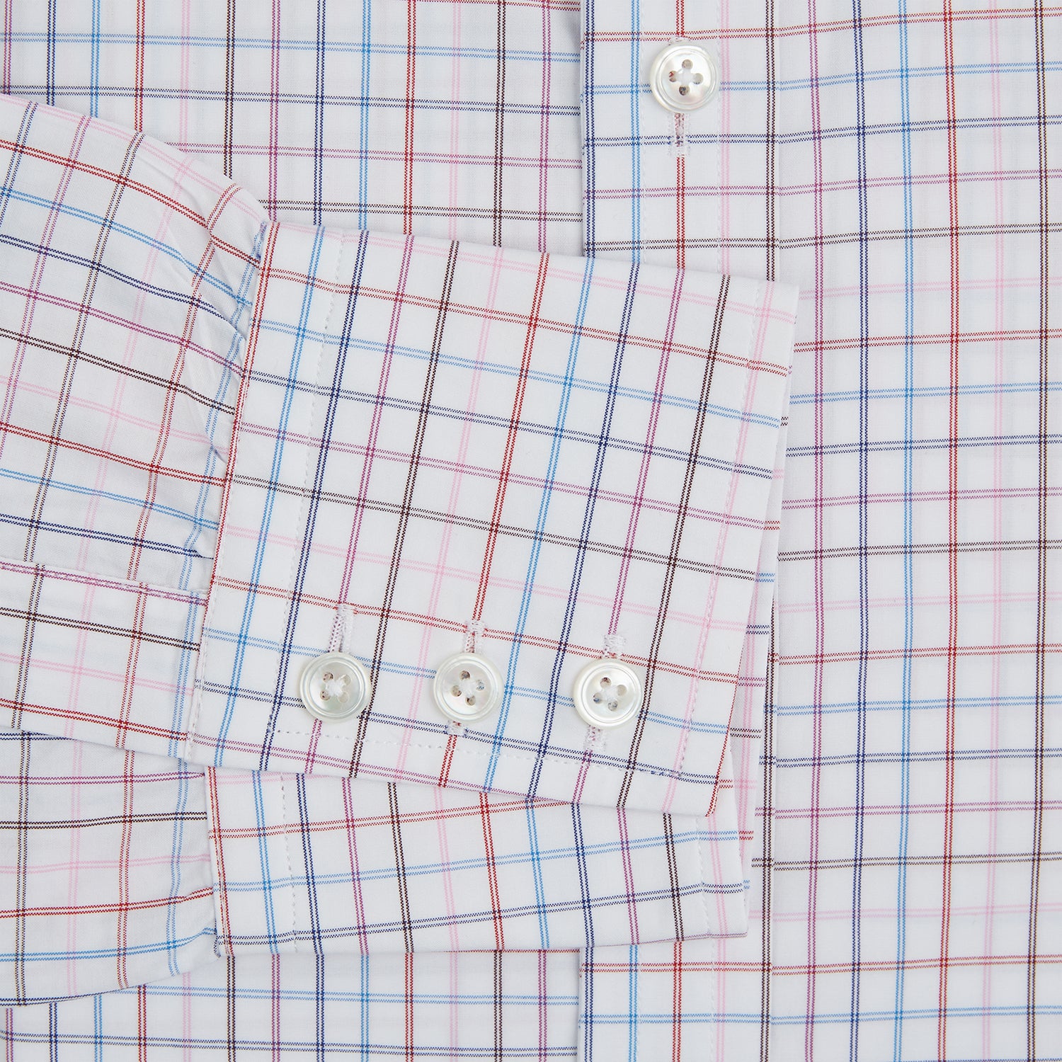 View 3 of product The Turnbull & Asser Pink Multi Double Grid Check Mayfair Shirt, made from organic cotton with a pointed collar and buttoned cuffs, features a light pink base with blue and red grid checks and is shown flat on a white background.