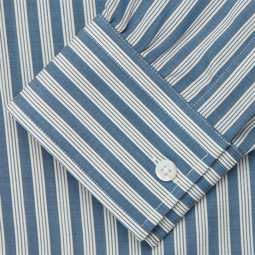 Turnbull & Asser’s Pale Blue Multi Stripe Weekend Fit Wool Shirt features a Derby collar, 1-button cuffs, and a chest pocket—ideal for casual layering. Shown laid flat on a white background for easy styling.