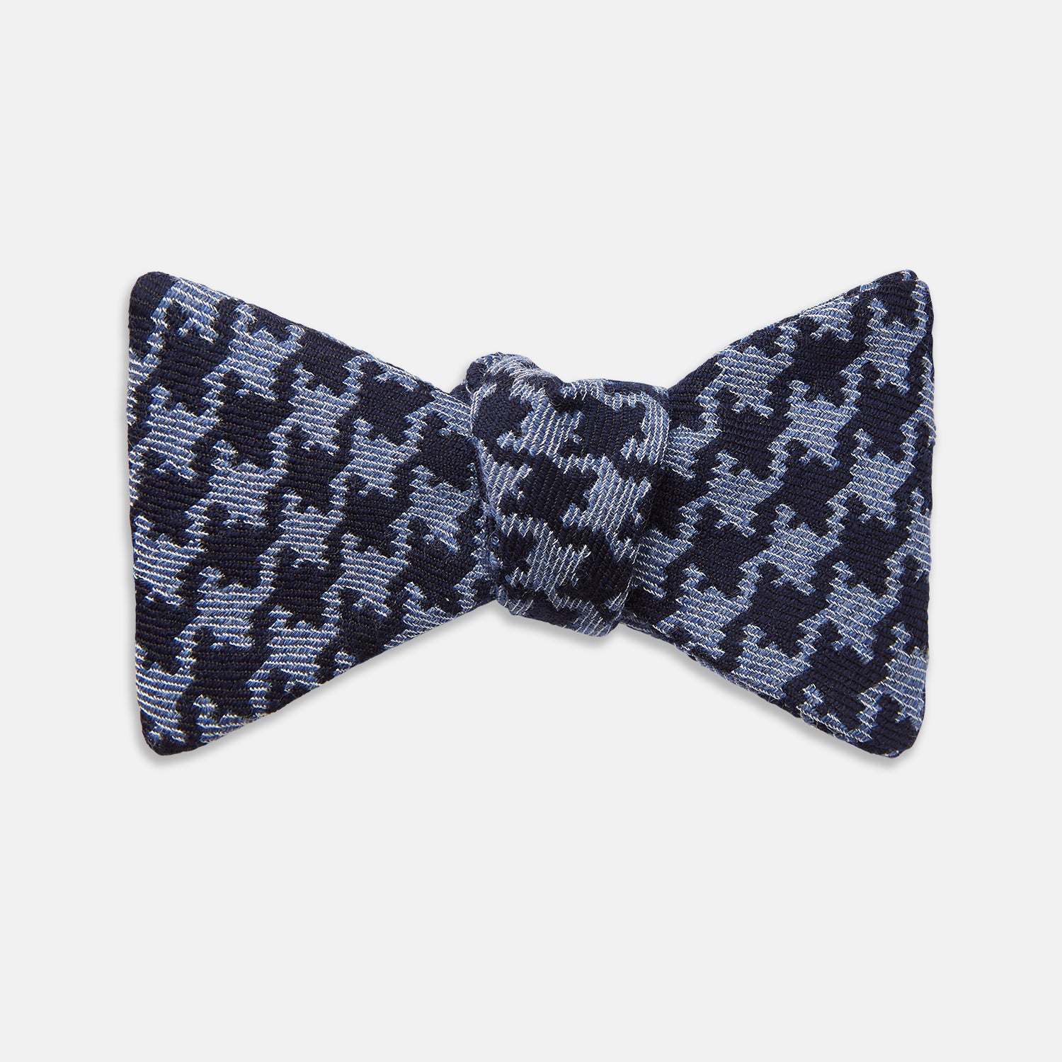 View 1 of product The Turnbull & Asser Navy and Blue Houndstooth Wool Blend Bow Tie features a self-tying design with a blue and black houndstooth pattern, showcased on a plain white background.