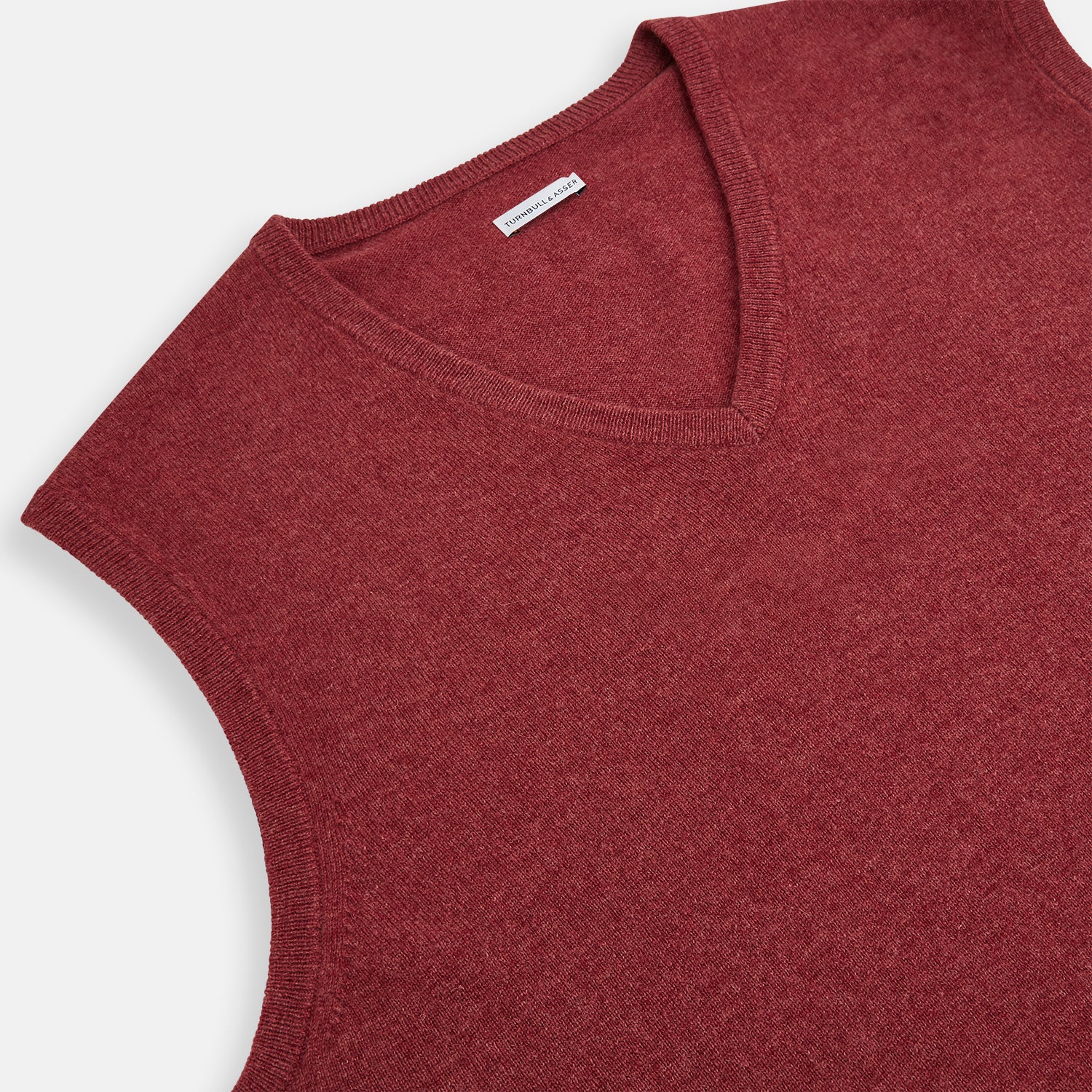 View 2 of product A refined piece from Turnbull & Asser, the Antique Pink Cashmere V-Neck Vest features a sleeveless design with a ribbed hem, shown against a plain white background.