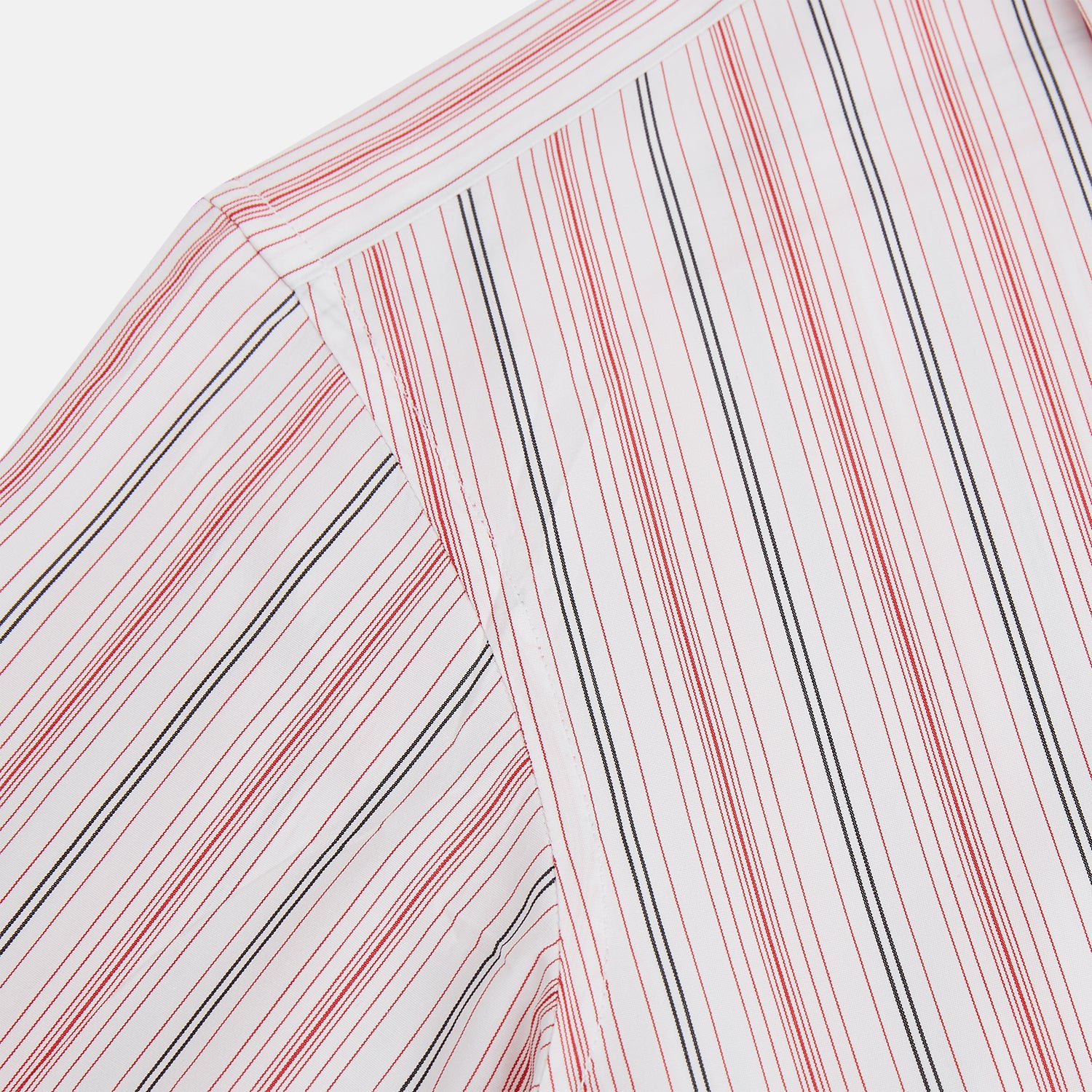 View 6 of product The Red Multi Pencil Stripe Windsor Shirt by Turnbull & Asser features long sleeves, buttoned cuffs, a Turnbull collar, and classic British tailoring with vertical red, pink, and white stripes.