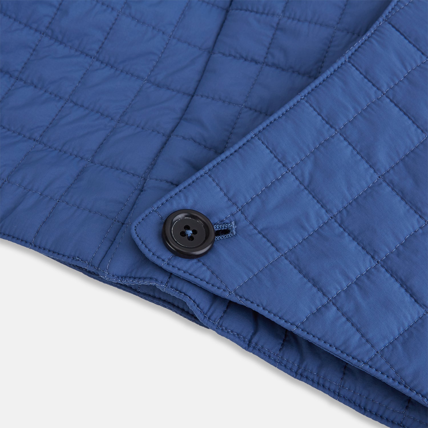 View 5 of product The Turnbull & Asser Azzurro Quilted Hood with Neck Warmer features a grid-stitched pattern, button closure, and overlapping front for added style. It draws inspiration from classic quilted jackets and is shown on a plain white background.