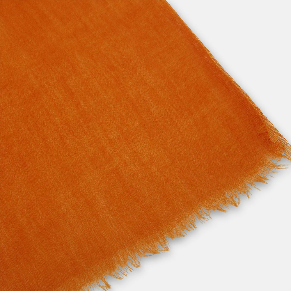 The Orange Cashmere Scarf by Turnbull & Asser features a soft texture, fringed edges, and a rich orange hue—an elegant luxury accessory displayed on a white background.