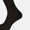 View 4 of product A single Turnbull & Asser Black Cotton Long Sock is shown upright on a white background, featuring a ribbed texture along the leg and foot with a smooth finish at the top.
