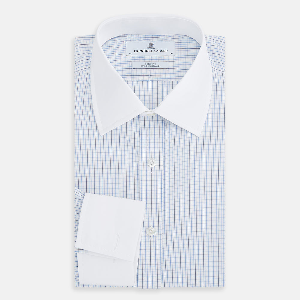 The Turnbull & Asser Pale Blue and Navy Grid Check Shirt features a contrast T&A collar and cuffs, long sleeves, and a button-down front, all displayed on a plain white background.