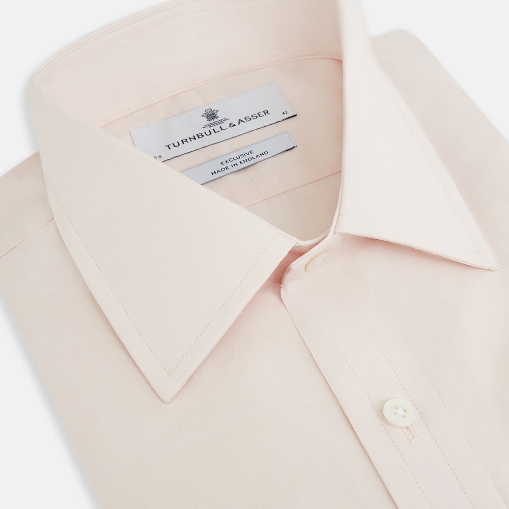 A plain, long-sleeve Pale Pink Mayfair Shirt by Turnbull & Asser with a T&A collar and buttoned cuffs, laid flat on a white background.