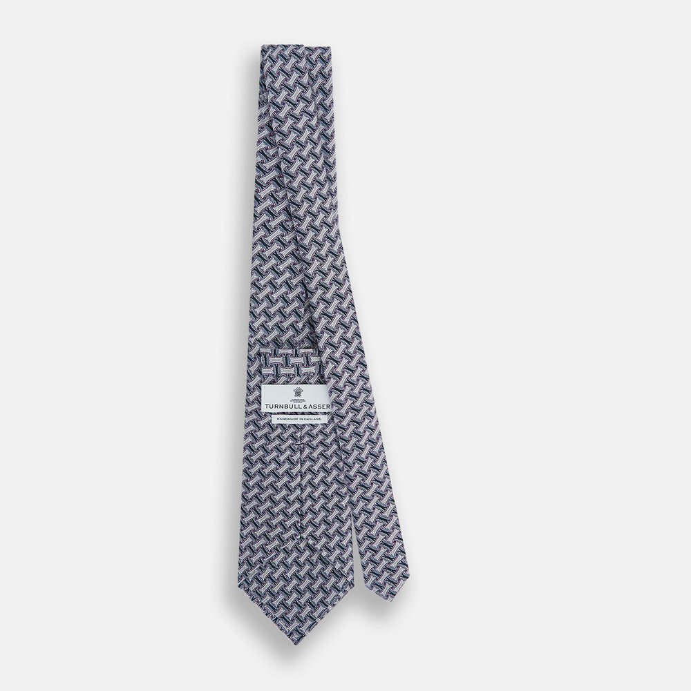 The Turnbull & Asser Navy and Pink Weave-Patterned Printed Silk Tie is shown rolled up on a white background, featuring a stylish geometric design.