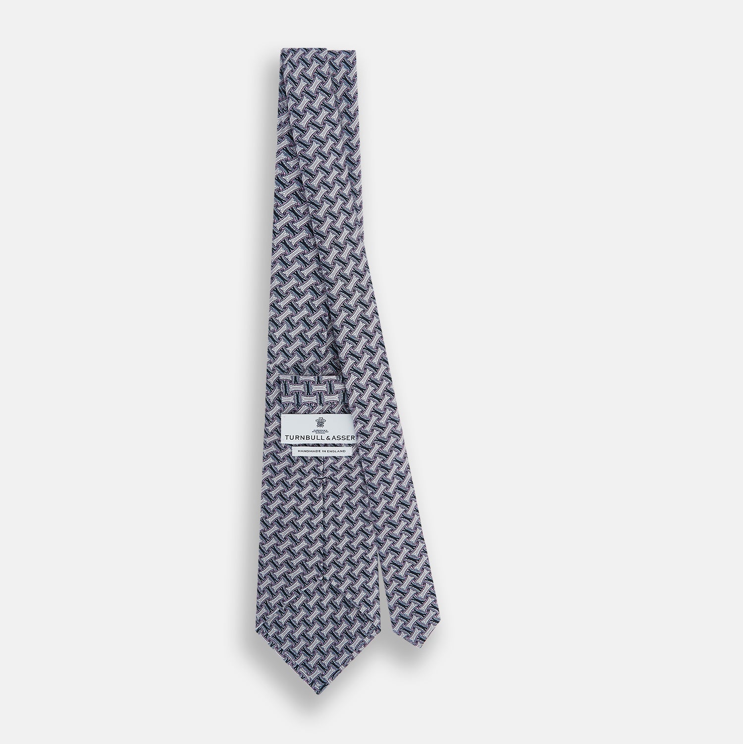 View 4 of product The Turnbull & Asser Navy and Pink Weave-Patterned Printed Silk Tie is shown rolled up on a white background, featuring a stylish geometric design.